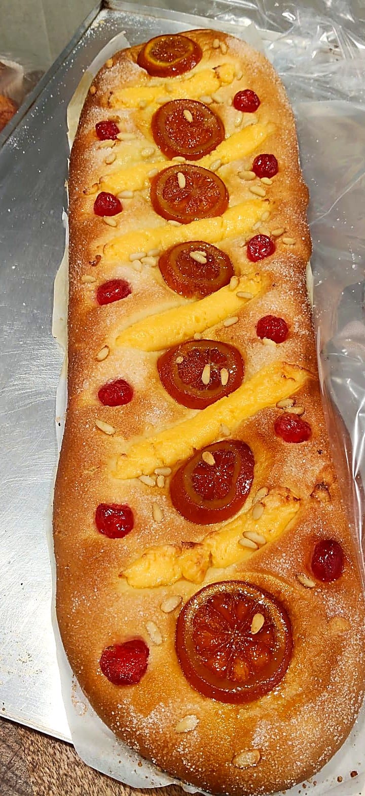 Coca de Sant Joan artesanal recién horneada con crema, naranja confitada y piñones